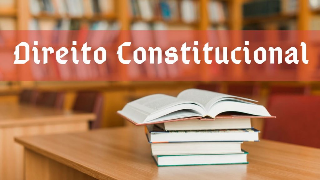Imagem com livros sobre uma mesa com o texto Direito Constitucional.